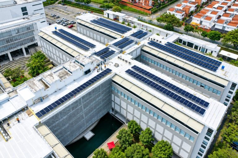 Cubierta de un edificio empresarial con varias filas de paneles solares y técnicos trabajando